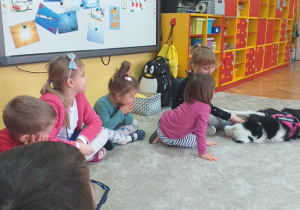 Na zdjęciu widać grupę dzieci z psem.